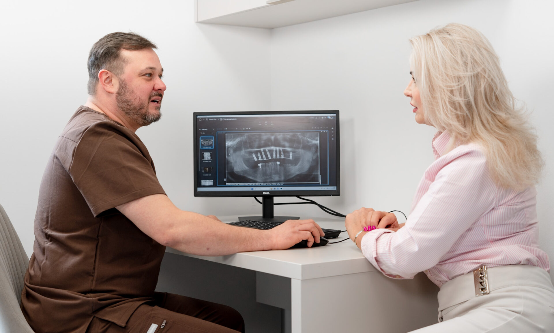 Konsultacja implantologiczna w Białymstoku – lekarz i pacjentka analizują skan CBCT przed wszczepieniem implantów zębów w gabinecie KralDent