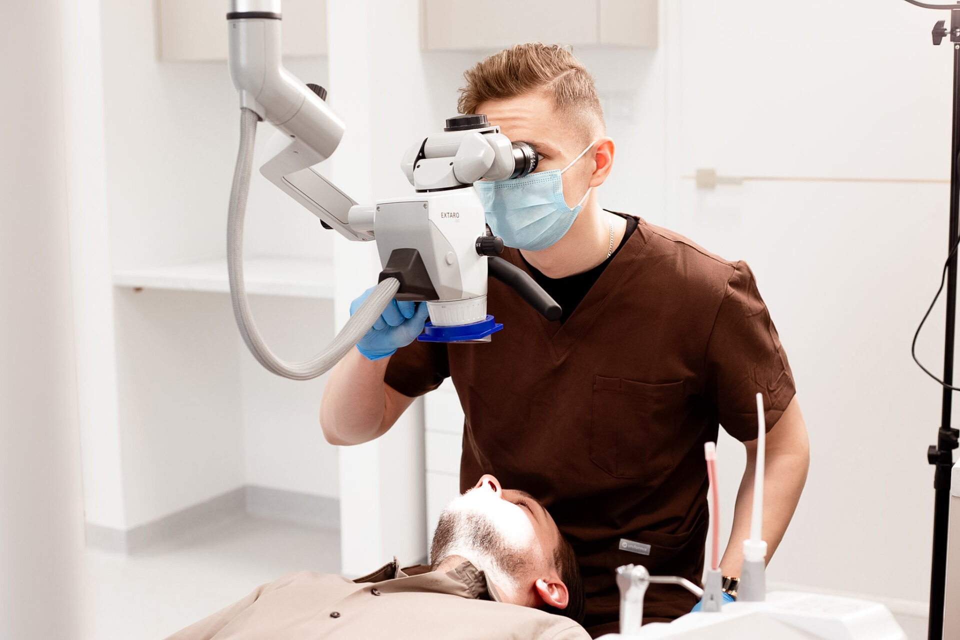 Dentysta podczas leczenia kanałowego pod mikroskopem stomatologicznym w gabinecie KralDent w Białymstoku