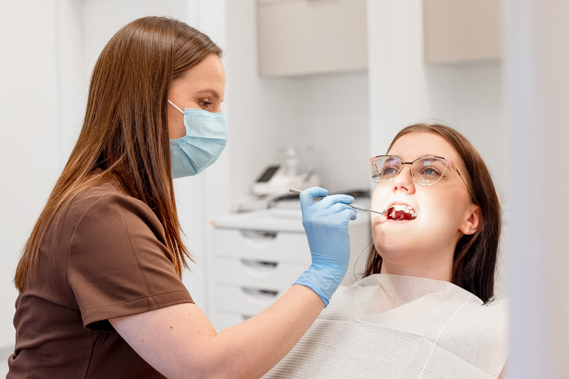 Periodontolog KralDent w Białymstoku bada dziąsła pacjentki podczas diagnostyki chorób przyzębia – leczenie periodontologiczne w gabinecie